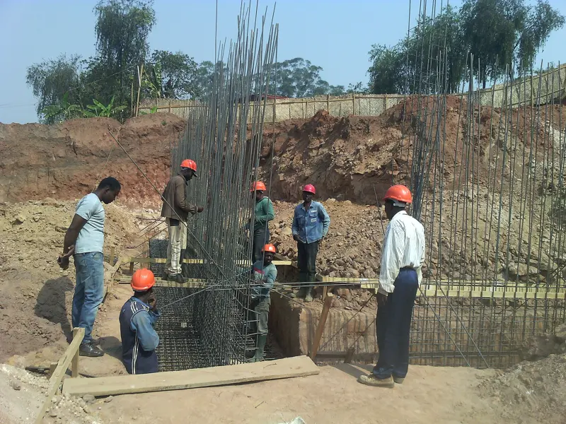 Crew building reinforced concrete foundations for a larger building